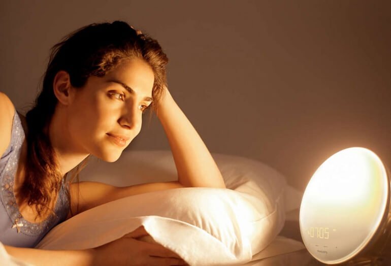 Woman waking up to the Philips HF3520 Wake-Up Light